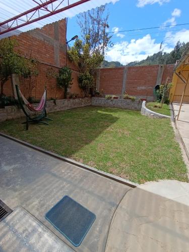 a patio with a hammock in a yard at Casa Alojamiento Tocllaraju in Tarica