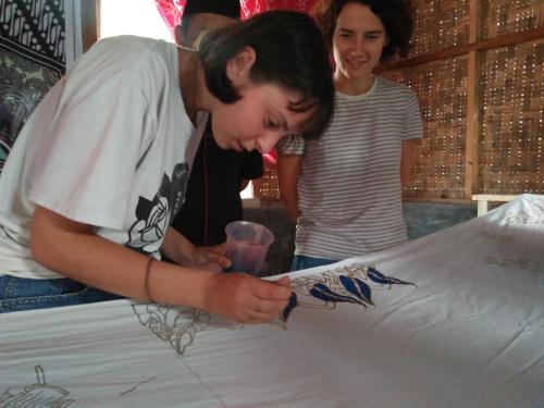 a young man signing a piece of paper on a bed at Bello Bungalow in Batukliang