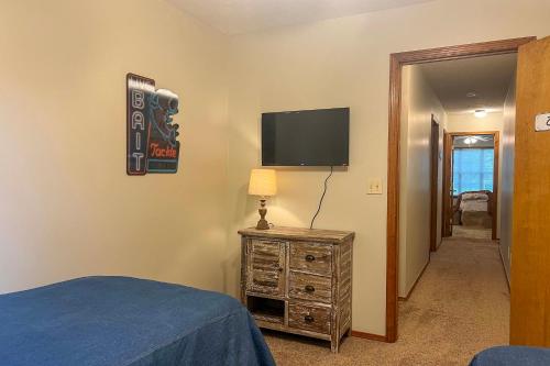 a bedroom with a bed and a tv on the wall at Less Than 1 Mi to Bull Shoals Lake The Blue Quill in Bull Shoals