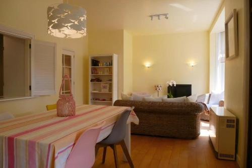 a living room with a table with chairs and a couch at Albatros C0 in De Haan