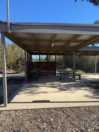 a picnic shelter with benches in a park at Central Deluxe Escape in Golden Square