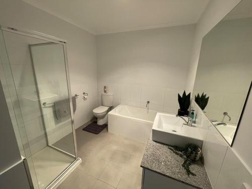 a bathroom with a shower and a sink and a toilet at Central Deluxe Escape in Golden Square