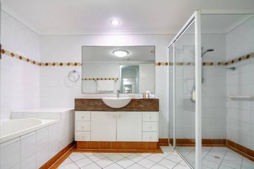 a white bathroom with a sink and a shower at Xanadu Escape - Seaside Resort near Surfers Paradise in Gold Coast