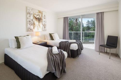 a hotel room with two beds and a window at Xanadu Escape - Seaside Resort near Surfers Paradise in Gold Coast