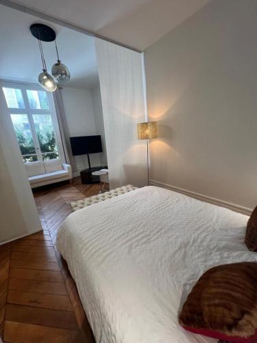 une chambre avec un grand lit blanc et une fenêtre dans l'établissement Luxury Flat étoile Champs Élysée Paris, à Paris