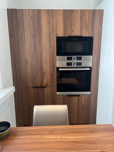 Il comprend une cuisine dotée d'un mur en bois et d'un four micro-ondes. dans l'établissement Luxury Flat étoile Champs Élysée Paris, à Paris