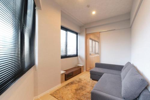 a living room with a couch and a window at Préciosité Chigasaki in Chigasaki