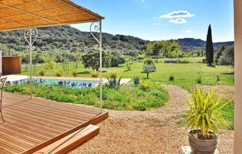 une arrière-cour avec un banc en bois et un jardin dans l'établissement Lovely Home In Valliguieres, à Valliguières