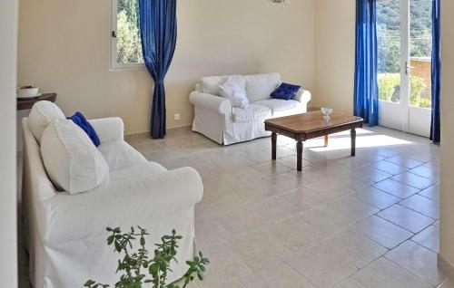 - un salon avec deux chaises blanches et une table basse dans l'établissement Lovely Home In Valliguieres, à Valliguières