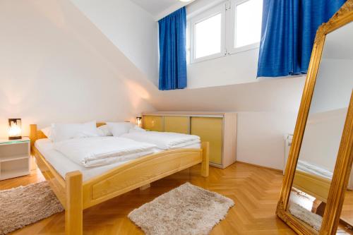 a bedroom with a bed with blue curtains and a mirror at Amigo Comfort Apartments in Split