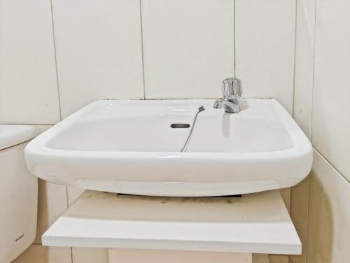 a white sink sitting on a shelf in a bathroom at Cozy 2BR Springlake Apt Bekasi with Pool & Gym by 2ndHome in Rawabugel
