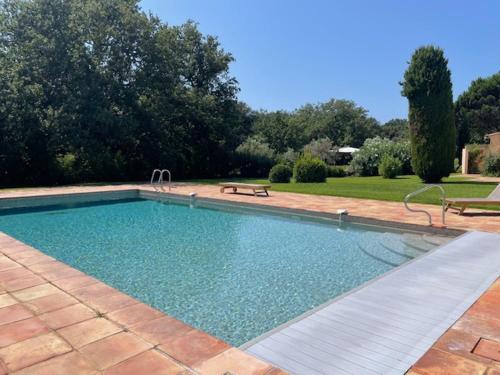 - une piscine avec un banc dans la cour dans l'établissement Le Petit Domaine, à Ramatuelle