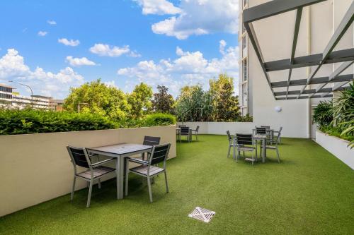 a patio with tables and chairs on a building at North Shore Oceanside Kawana in Kawana Waters