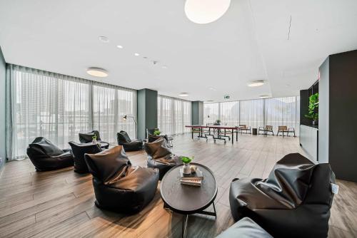 a living room with leather chairs and a table at Luxury Perth CBD Apartment with Pool & Gym - Sleeps 3 in Perth