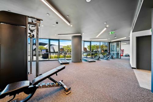 a gym with a row of exercise equipment in a building at Luxury Perth CBD Apartment with Pool & Gym - Sleeps 3 in Perth