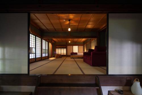 un soggiorno con una grande parete in vetro di Satoyama Villa Honjin a Matsumoto