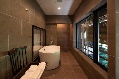 un bagno con vasca e finestra di Satoyama Villa Honjin a Matsumoto