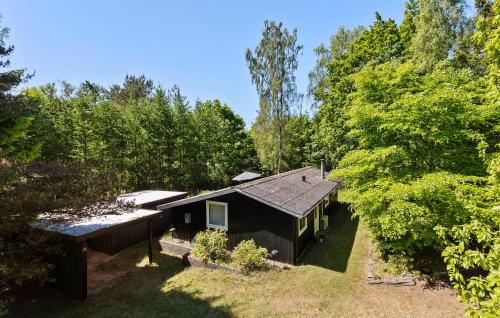 a black house in the middle of a forest at 3 Bedroom Stunning Home In Glesborg in Glesborg