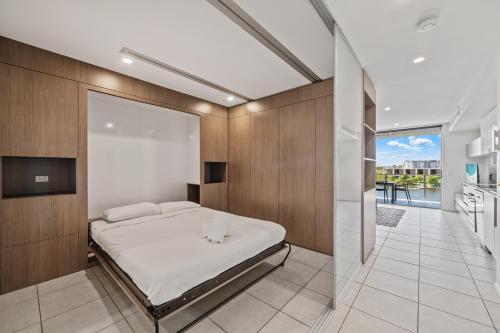 a bedroom with a bed and a glass wall at North Shore Oceanside Kawana in Kawana Waters