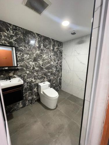 a bathroom with a toilet and a tv on the wall at Radiant Heights Hotel by KK Inn in Ampang