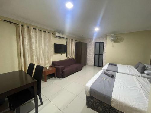 a bedroom with a bed and a desk and a couch at Radiant Heights Hotel by KK Inn in Ampang