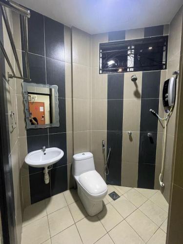 a bathroom with a toilet and a sink at Radiant Heights Hotel by KK Inn in Ampang
