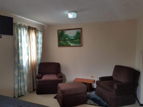 a living room with a couch and a chair at Edinburg Aqueral The EA in Kupuis
