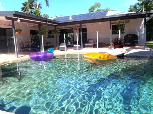 a swimming pool with two inflatables in a house at Quintessential Kewarra in Kewarra Beach