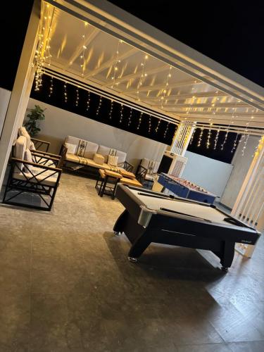 a living room with a pool table and chairs at Valley View farm in Maghribīyah