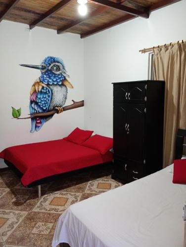 a bedroom with a blue bird on a branch at EcoHotel Colibrí Salento in Luna Park