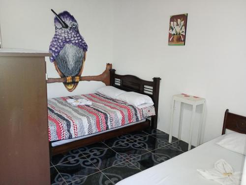 a small bedroom with two beds and aulture bust on the wall at EcoHotel Colibrí Salento in Luna Park