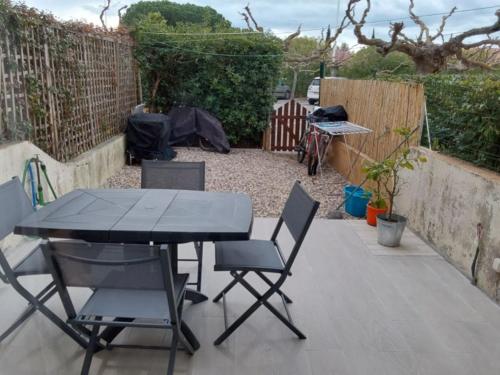 d'une terrasse avec une table et des chaises dans l'arrière-cour. dans l'établissement Appartemment Grau du Roi Résidence Camargue village, au Grau-du-Roi