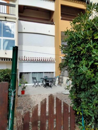 une clôture devant une maison avec une table dans l'établissement Appartemment Grau du Roi Résidence Camargue village, au Grau-du-Roi