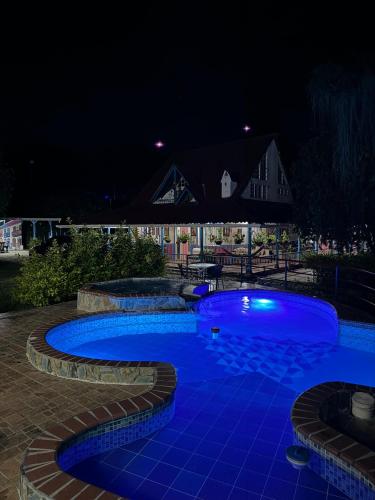 a swimming pool at night with blue lighting at EcoHotel Colibrí Salento in Luna Park