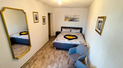 a bedroom with a bed and a mirror and a chair at Golden Hop Apartments in Senftenberg