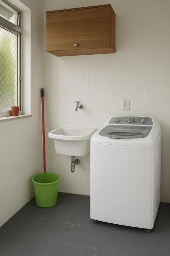 a white kitchen with a sink and a stove at Apto aconchegante, central, prox ao carrefour in Santa Maria