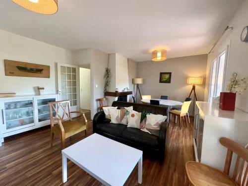 un salon avec un canapé et une table dans l'établissement Maison 3 Chambres avec Jardin et Wi-Fi à 10 min de la Plage, Quartier Calme, Animaux Acceptés - FR-1-323-370, à Saint-Jean-de-Monts