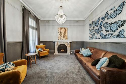 a living room with a couch and a fireplace at Mount Stuart House in Daylesford