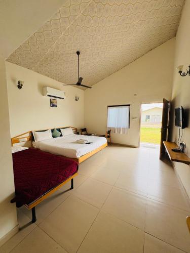 a large bedroom with a bed and a tv at Unity Sunrise Resort Best Hotel Near Statue of Unity in Kevadia