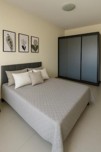 a bedroom with a large bed with white pillows at Apto aconchegante, central, prox ao carrefour in Santa Maria