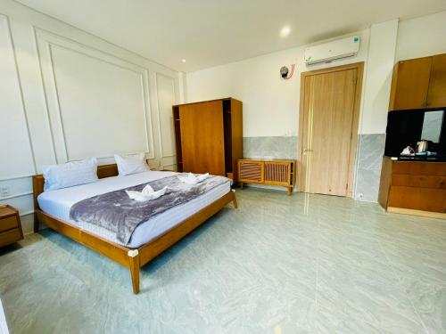 a bedroom with a bed and a television in it at Tropical Mango House in Da Nang
