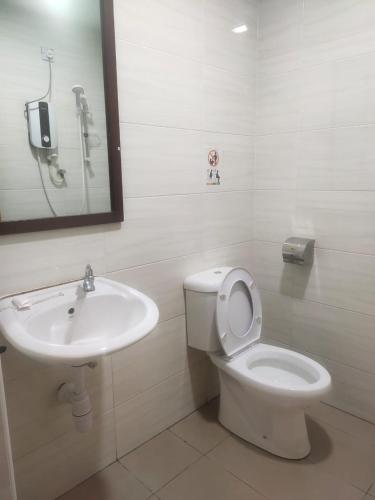 a bathroom with a white toilet and a sink at S&P Hotel in Tampin