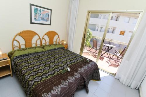 カンブリルスにあるMagica Planet Costa Doradaのベッドルーム1室(ベッド1台付)、パティオへのドアが備わります。