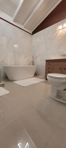 a white bathroom with a tub and a toilet at Chateau Bellview in Falmouth