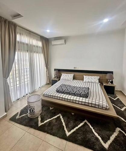 ein Schlafzimmer mit einem großen Bett und einem großen Fenster in der Unterkunft OBDP House in Abidjan