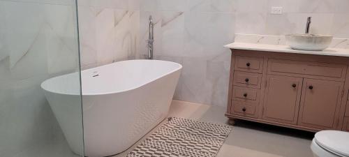 a bathroom with a tub and a sink and a toilet at Chateau Bellview in Falmouth