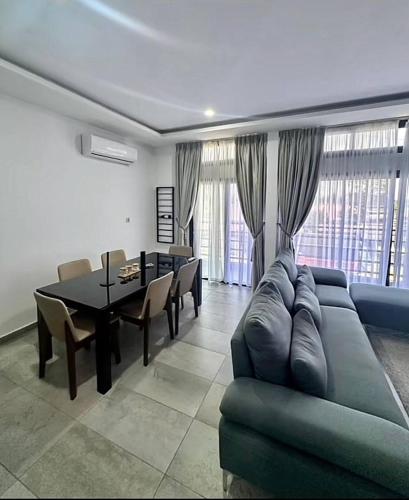 ein Wohnzimmer mit Sofa, Tisch und Stühlen in der Unterkunft OBDP House in Abidjan