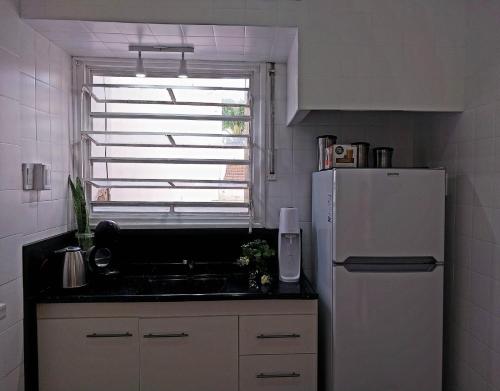 Una cocina con un refrigerador blanco y una ventana. en Apartamento de 3 Habitaciones en el Centro, en Villa María