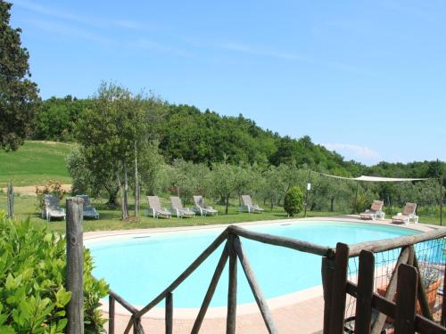 a swimming pool with chairs and a fence at Apartment in Guasticce with shared pool in Guasticce