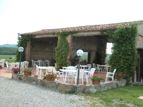 a group of white chairs sitting outside of a building at Apartment in Guasticce with shared pool in Guasticce